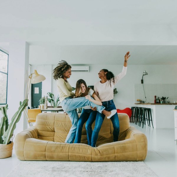 Diverse group of female friends enjoying party and laughing together – Women friends having fun at home dancing on the couch – Happy lifestyle and friendship concept Diverse group of female friends enjoying party and laughing together - Women friends having fun at home dancing on the couch - Happy lifestyle and friendship concept