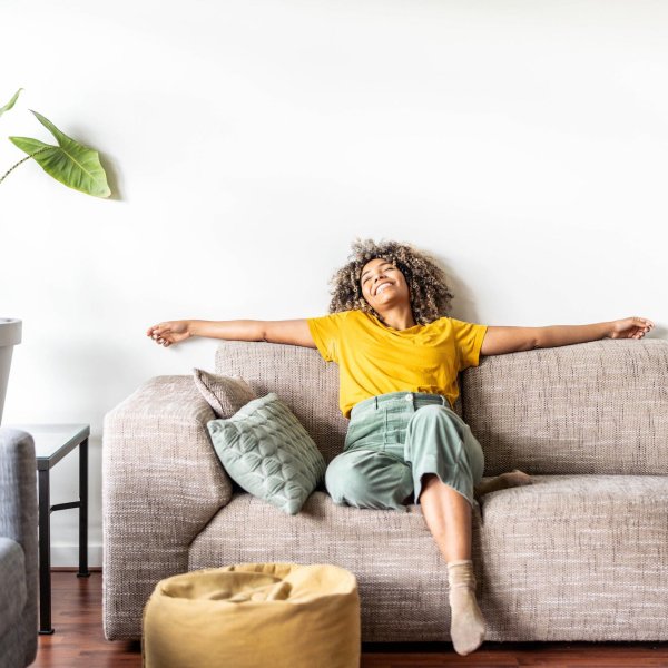 Happy afro american woman relaxing on the sofa at home – Smiling girl enjoying day off lying on the couch – Healthy life style, good vibes people and new home concept Happy afro american woman relaxing on the sofa at home - Smiling girl enjoying day off lying on the couch - Healthy life style, good vibes people and new home concept
